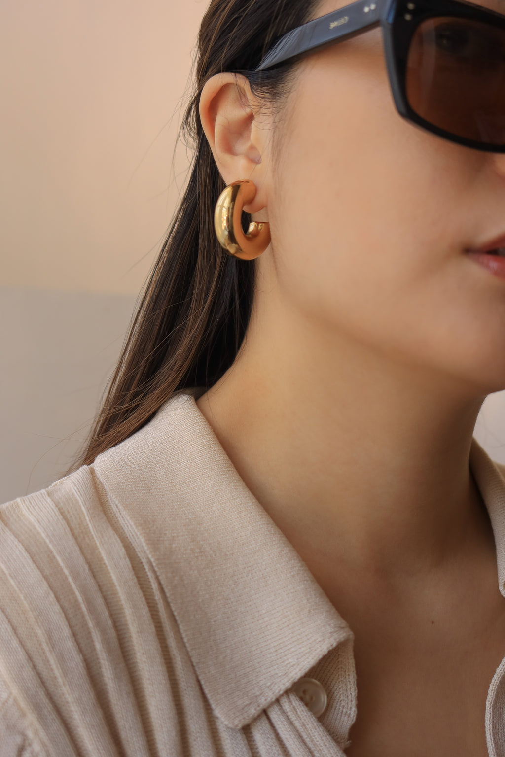 Gold chunky hoop earrings with a glossy finish, designed as bold statement pieces for stylish accessorizing.