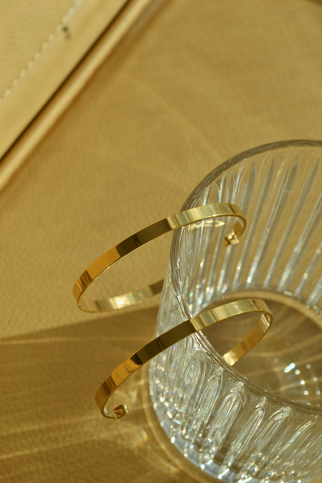 Large glossy gold hoop earrings with a smooth, shiny finish, reflecting light elegantly.