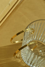 Large glossy gold hoop earrings with a smooth, shiny finish, reflecting light elegantly.