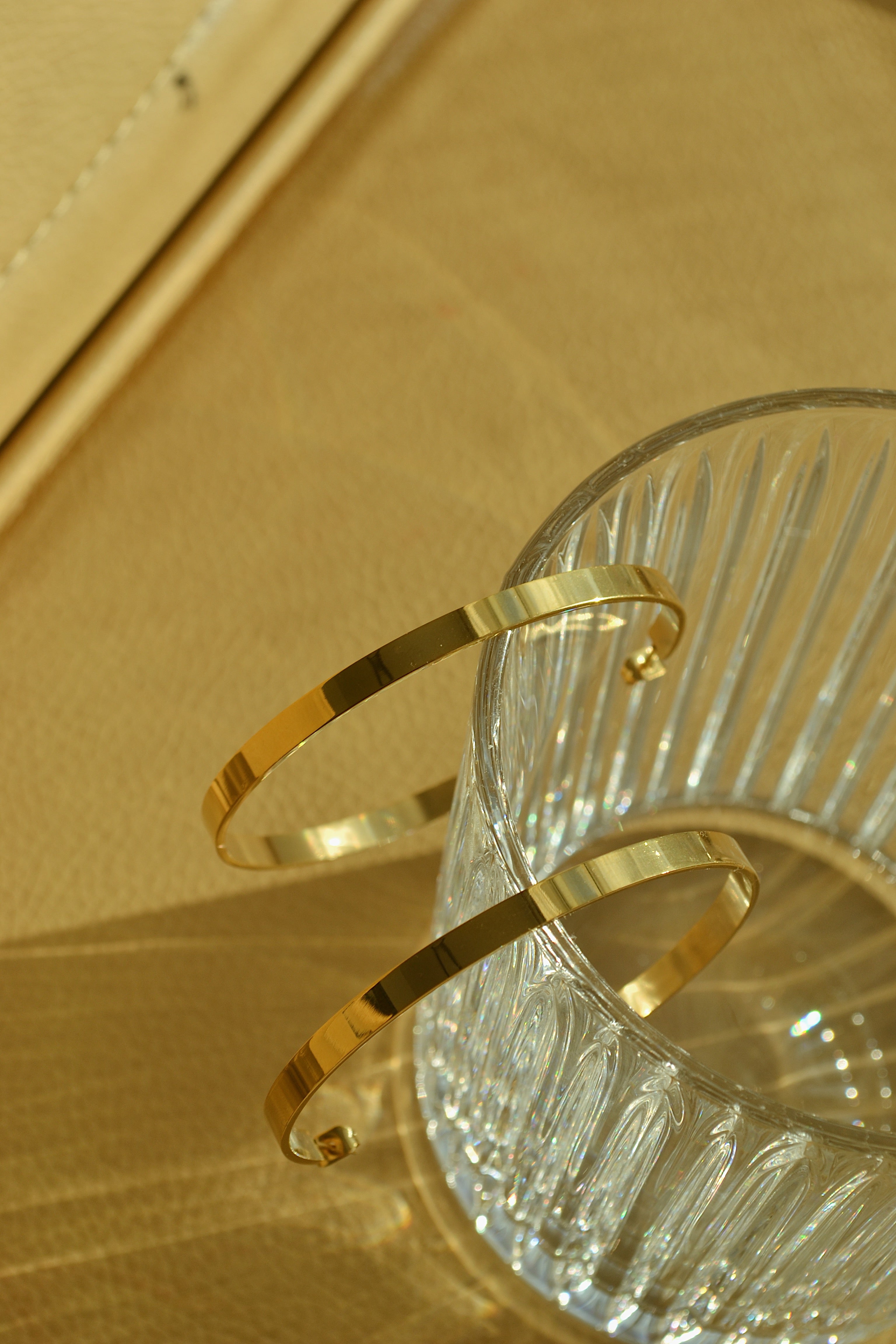 Large glossy gold hoop earrings with a smooth, shiny finish, reflecting light elegantly.