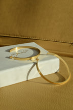Large glossy gold hoop earrings with a smooth, shiny finish, reflecting light elegantly.