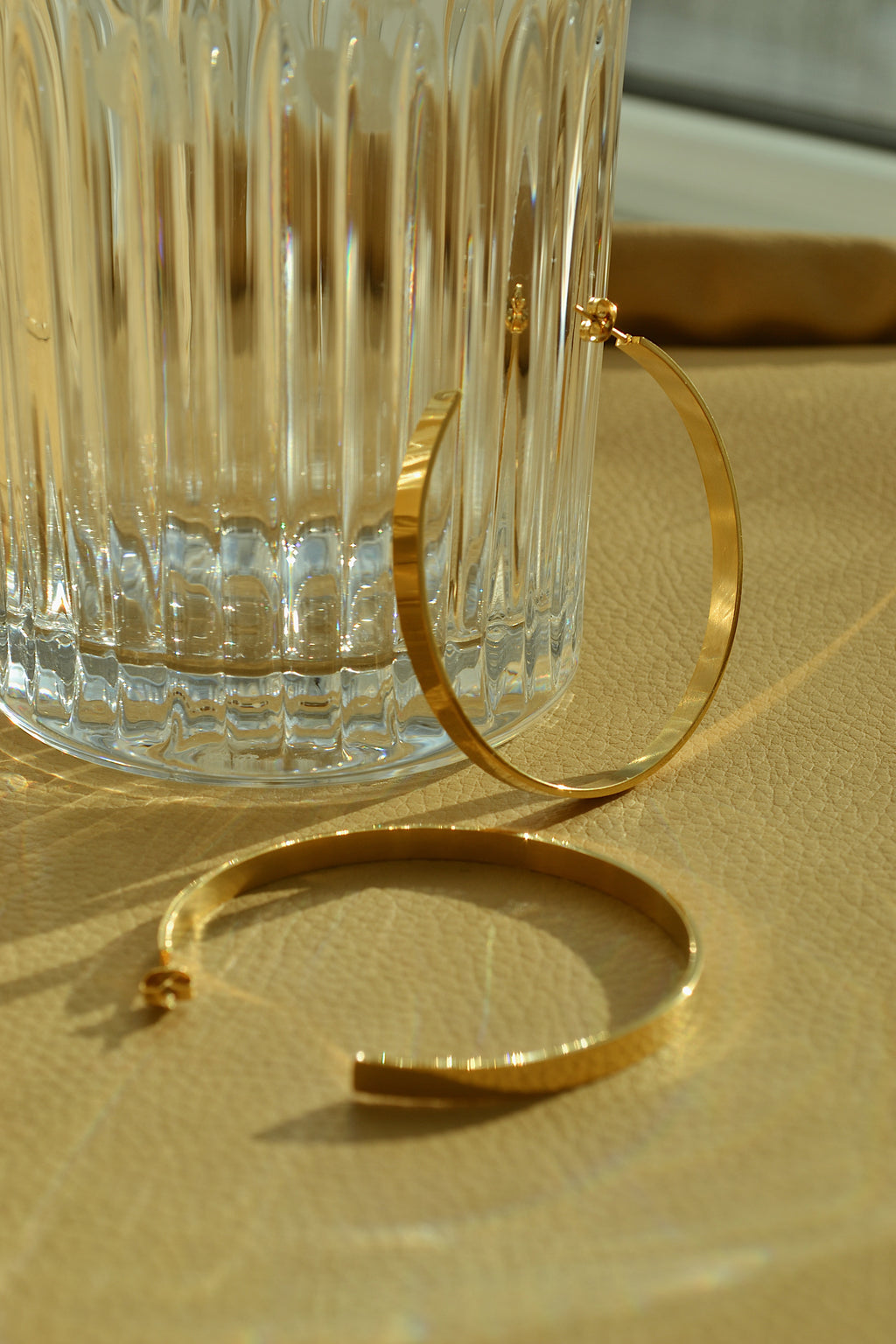 Large glossy gold hoop earrings with a smooth, shiny finish, reflecting light elegantly.