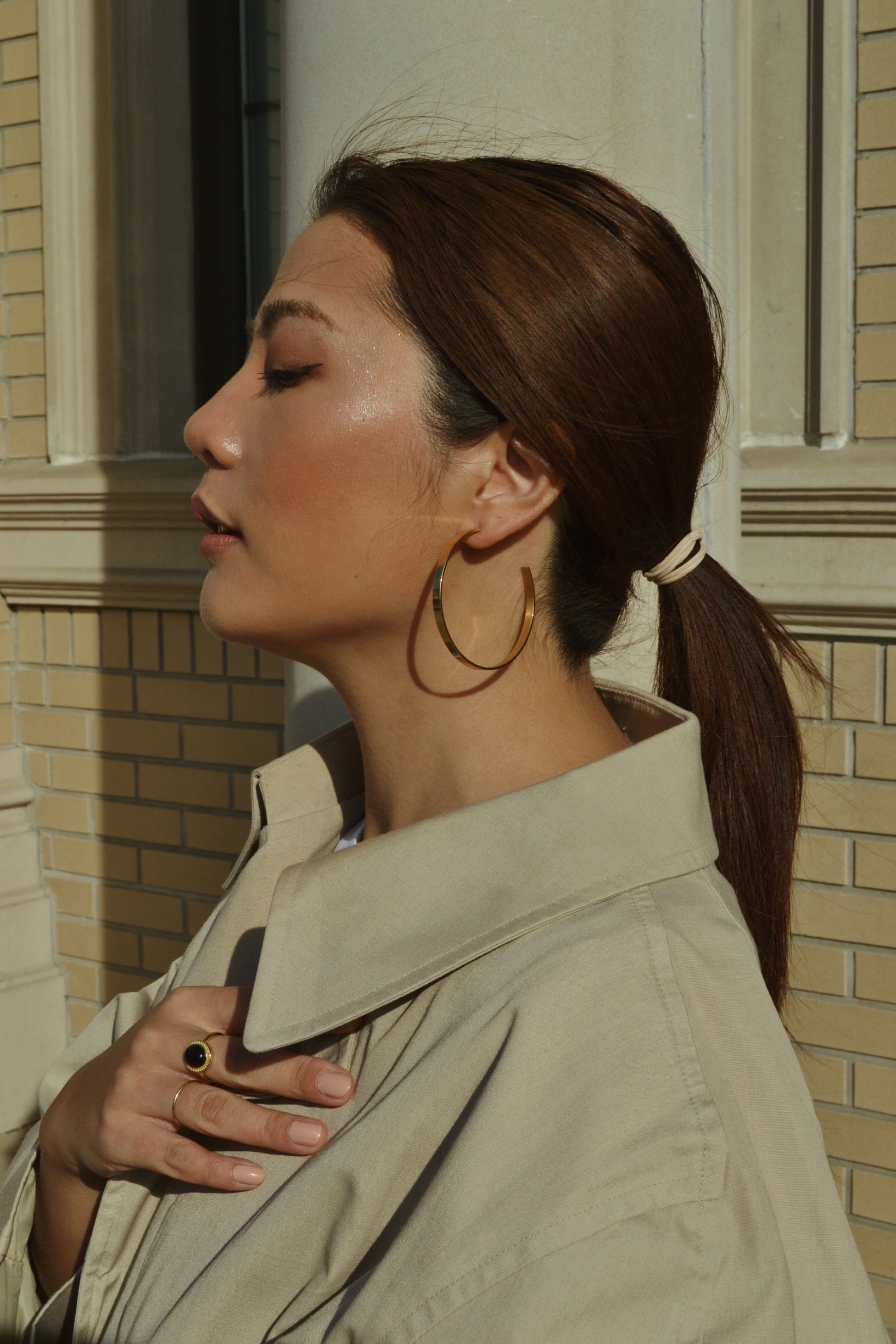 Large glossy gold hoop earrings with a smooth, shiny finish, reflecting light elegantly.