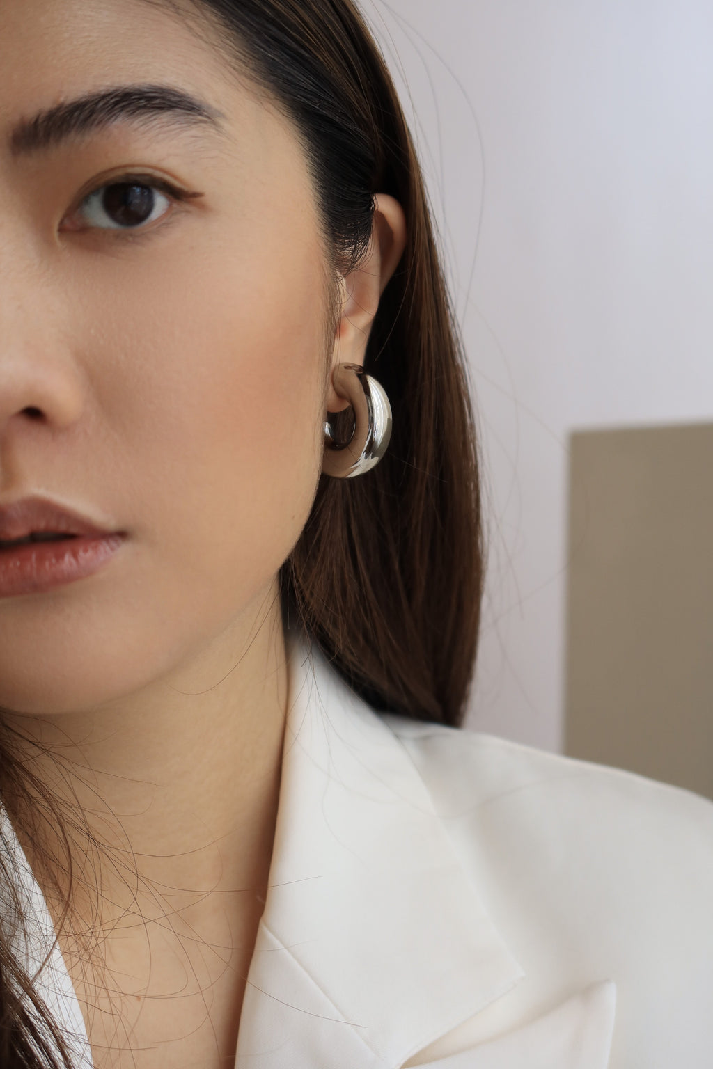 Silver chunky hoop earrings with a glossy finish, designed as bold statement accessories