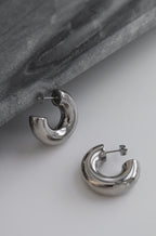Silver chunky hoop earrings with a glossy finish, designed as bold statement accessories