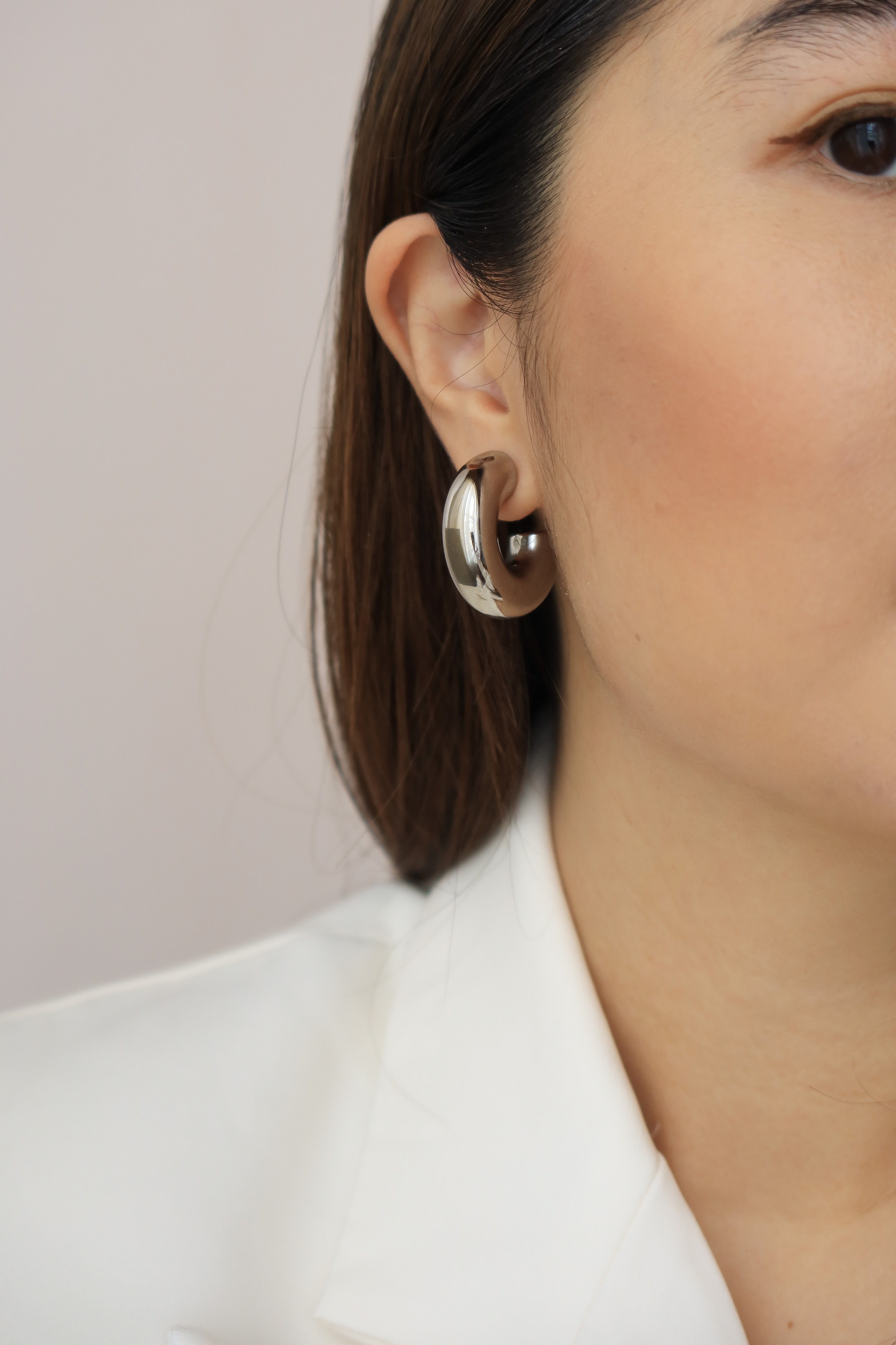 Silver chunky hoop earrings with a glossy finish, designed as bold statement accessories