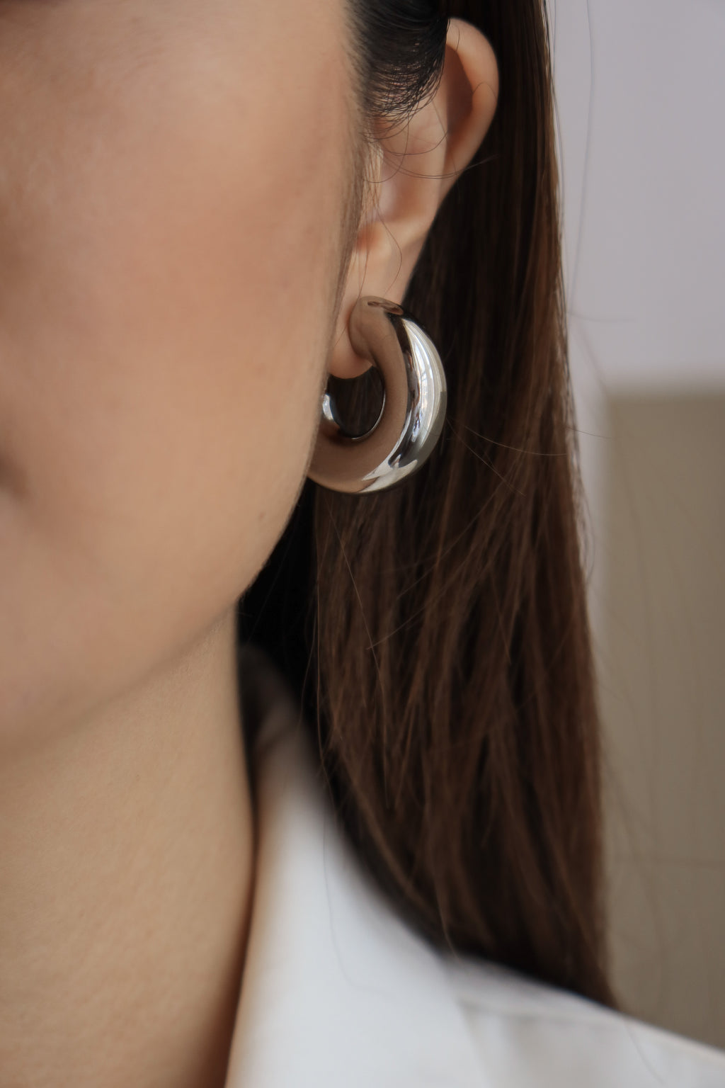 Silver chunky hoop earrings with a glossy finish, designed as bold statement accessories